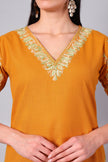 Close-up of mint green Kashmiri Aari embroidery on amber co-ord set neckline