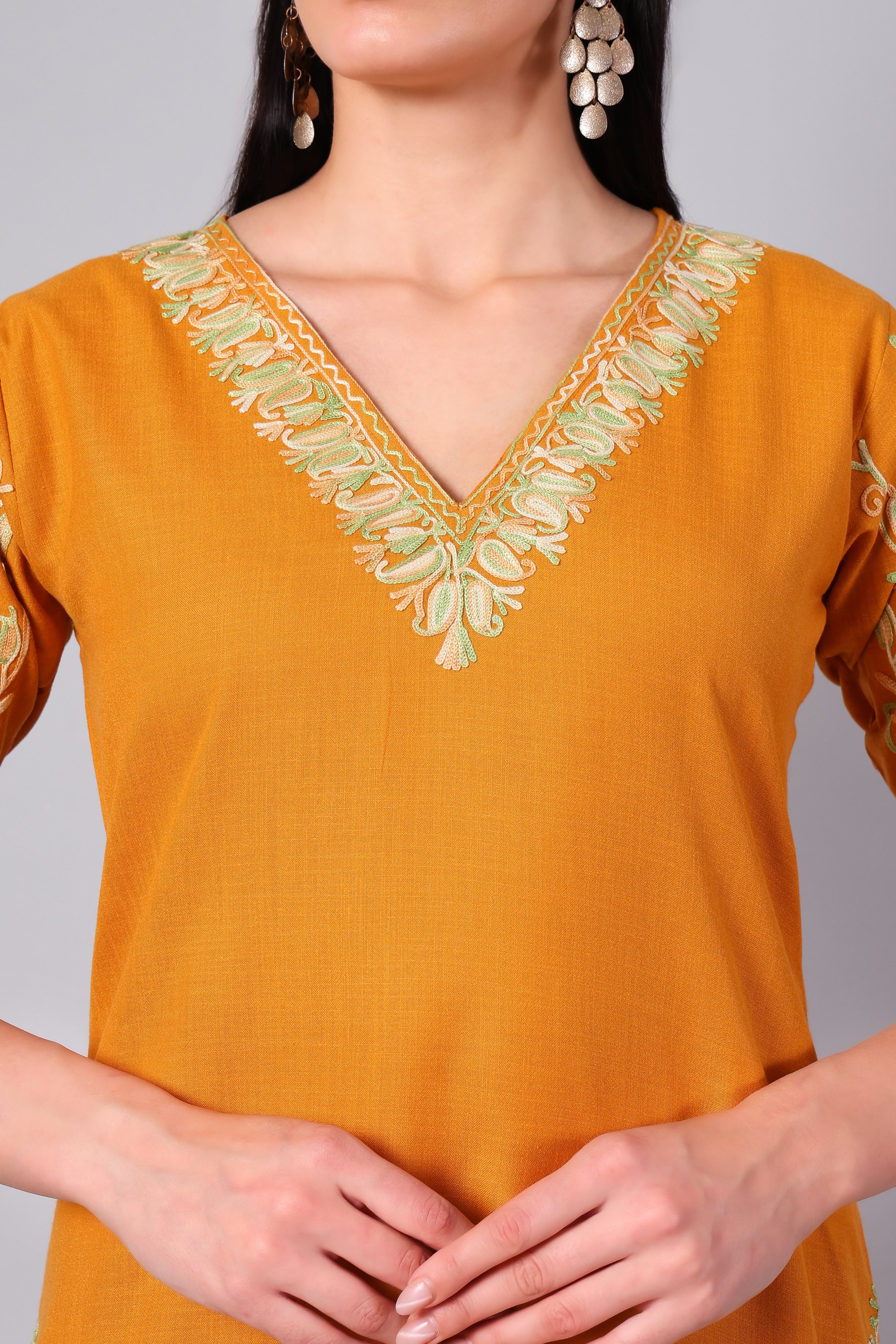 Close-up of mint green Kashmiri Aari embroidery on amber co-ord set neckline