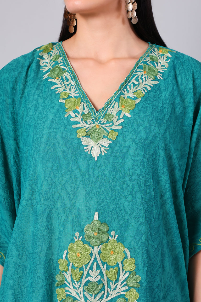 Close-up of tonal Kashmiri Aari floral embroidery on teal green kaftan neckline