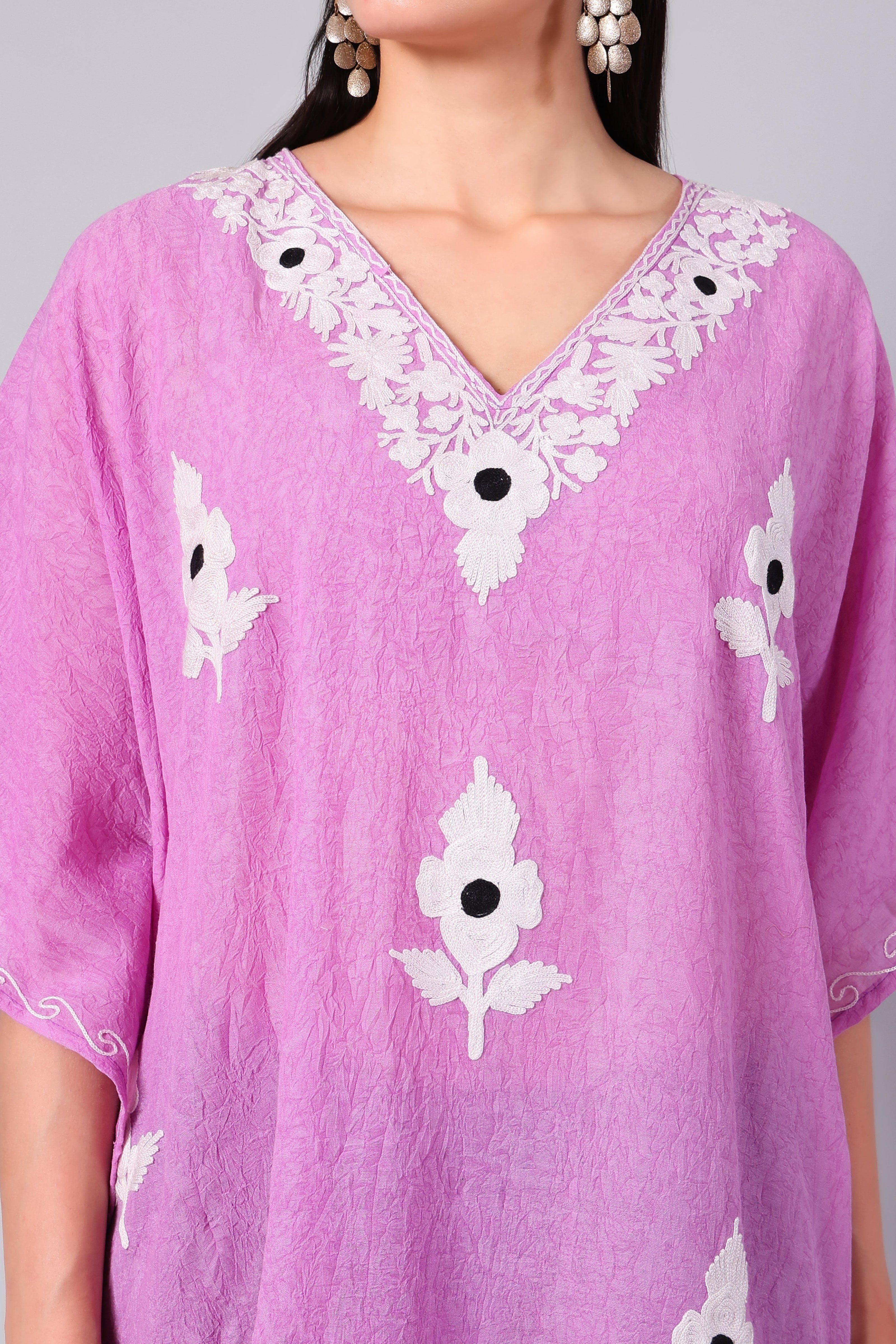 Close-up of white Kashmiri Aari floral embroidery on orchid pink kaftan neckline