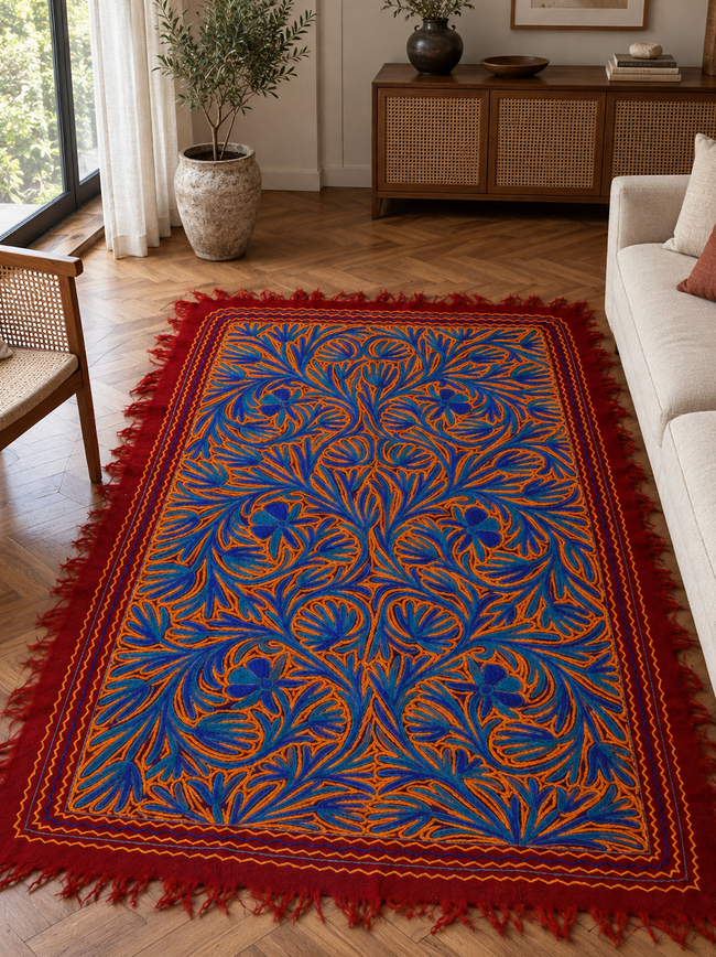 Surkh-o-Gul handmade Kashmiri Namda rug with jewel-tone floral embroidery on a deep crimson wool base