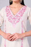 Close-up of pink Kashmiri Aari embroidery on white co-ord set neckline